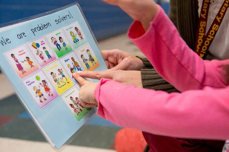 Child pointing at problem solving cards