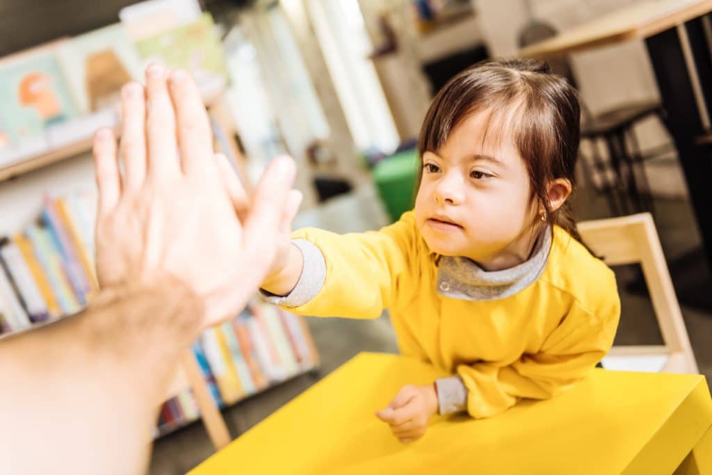 child giving high five to her teacher