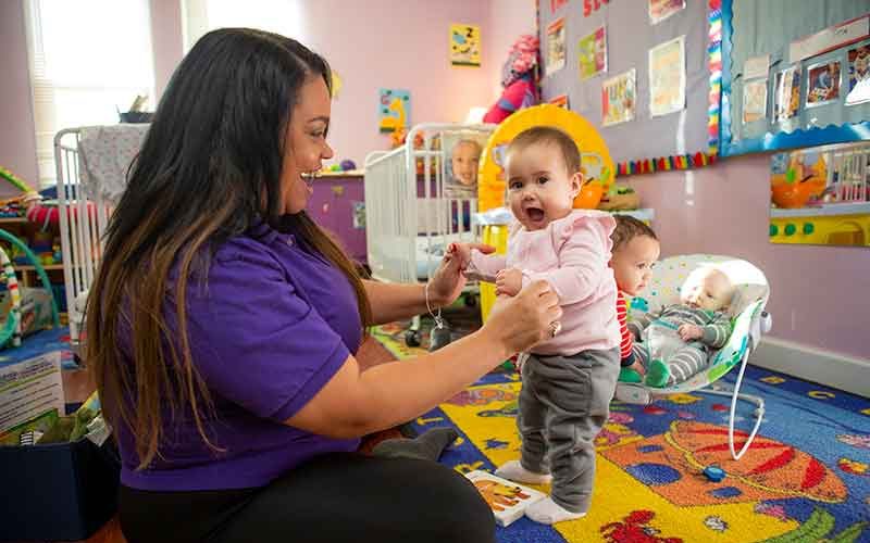 Teacher smiling at older infant