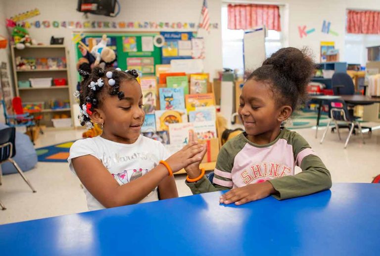 Two girls working together at a classroom table