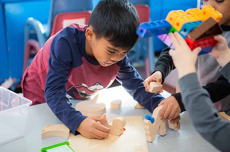 Boy trying to piece blocks together