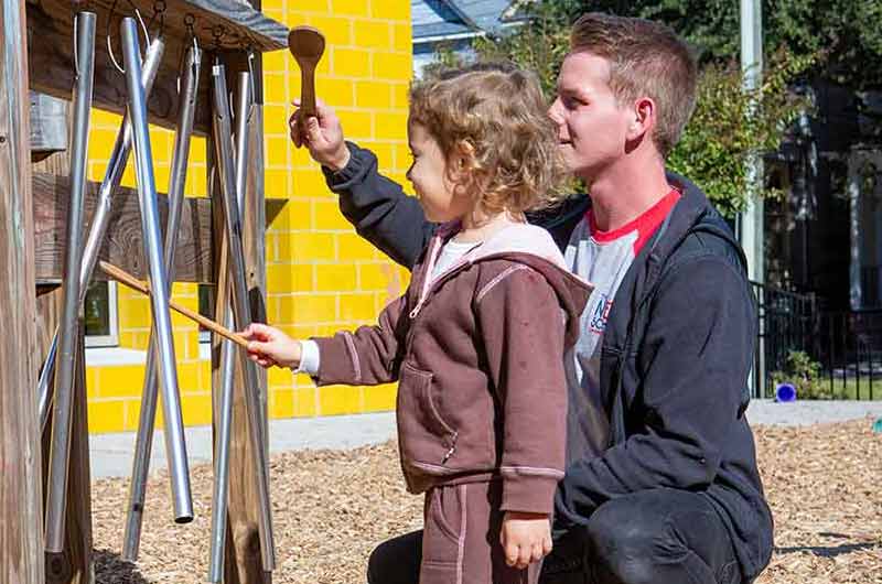 Young child exploring wind chimes