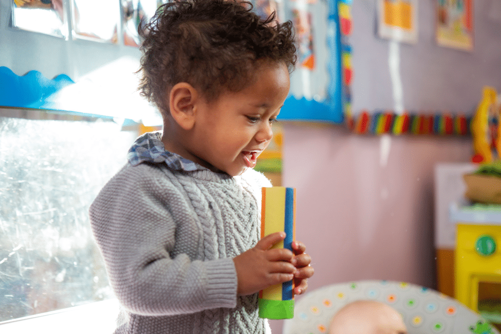 Toddler standing holding talking stick