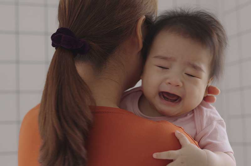 Educator consoling infant