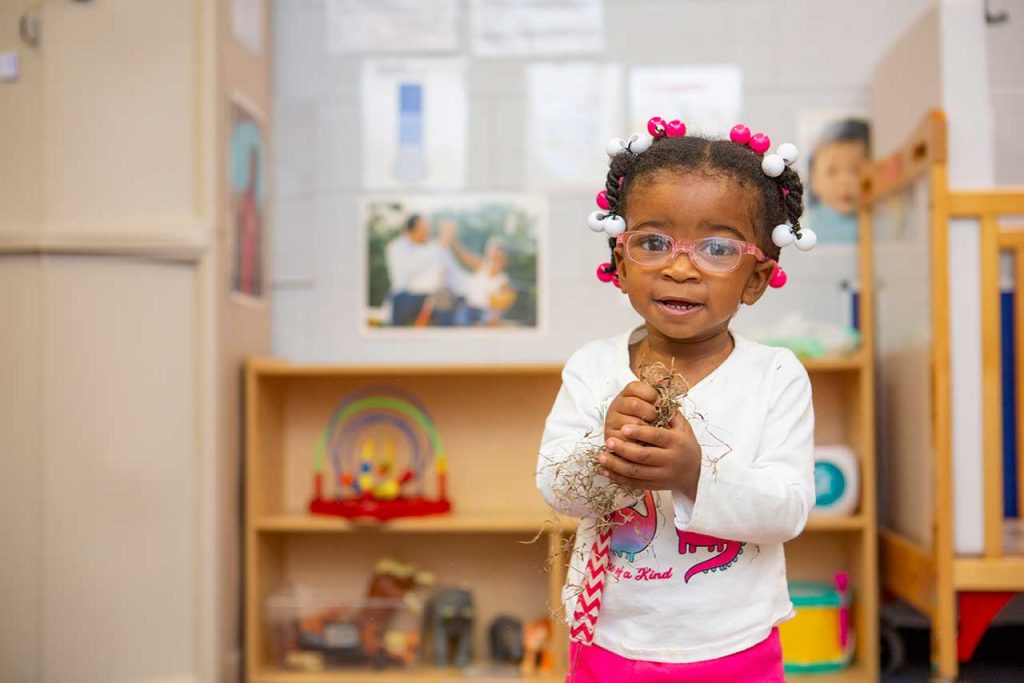 A toddler looking excitedly at the camera